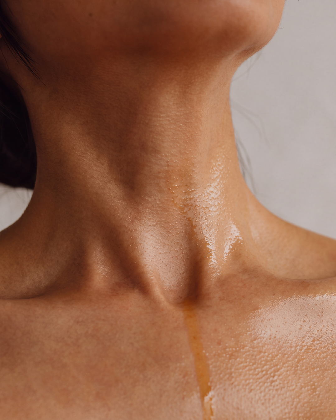 Water gliding over honey-toned skin after a shower